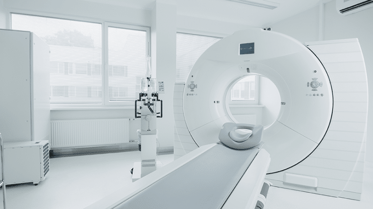 The image depicts a modern hospital laboratory featuring a CT, MRI, or PET scan. The space is equipped with advanced medical technology and is impeccably clean.