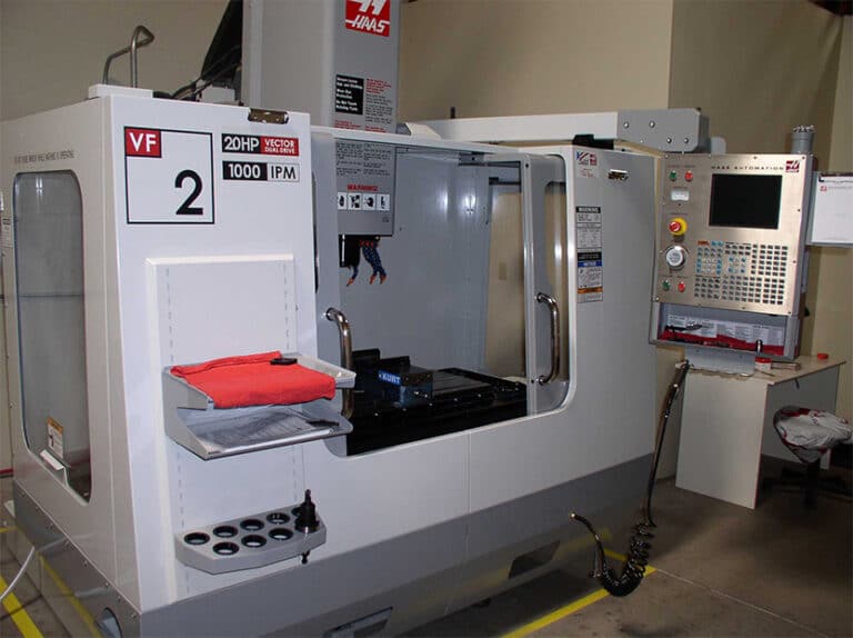 The image shows CNC milling equipment set up in a factory.