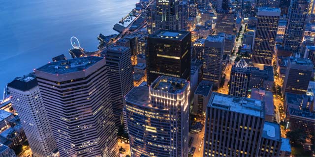 The photo depicts the Downtown Seattle Skyline at night.